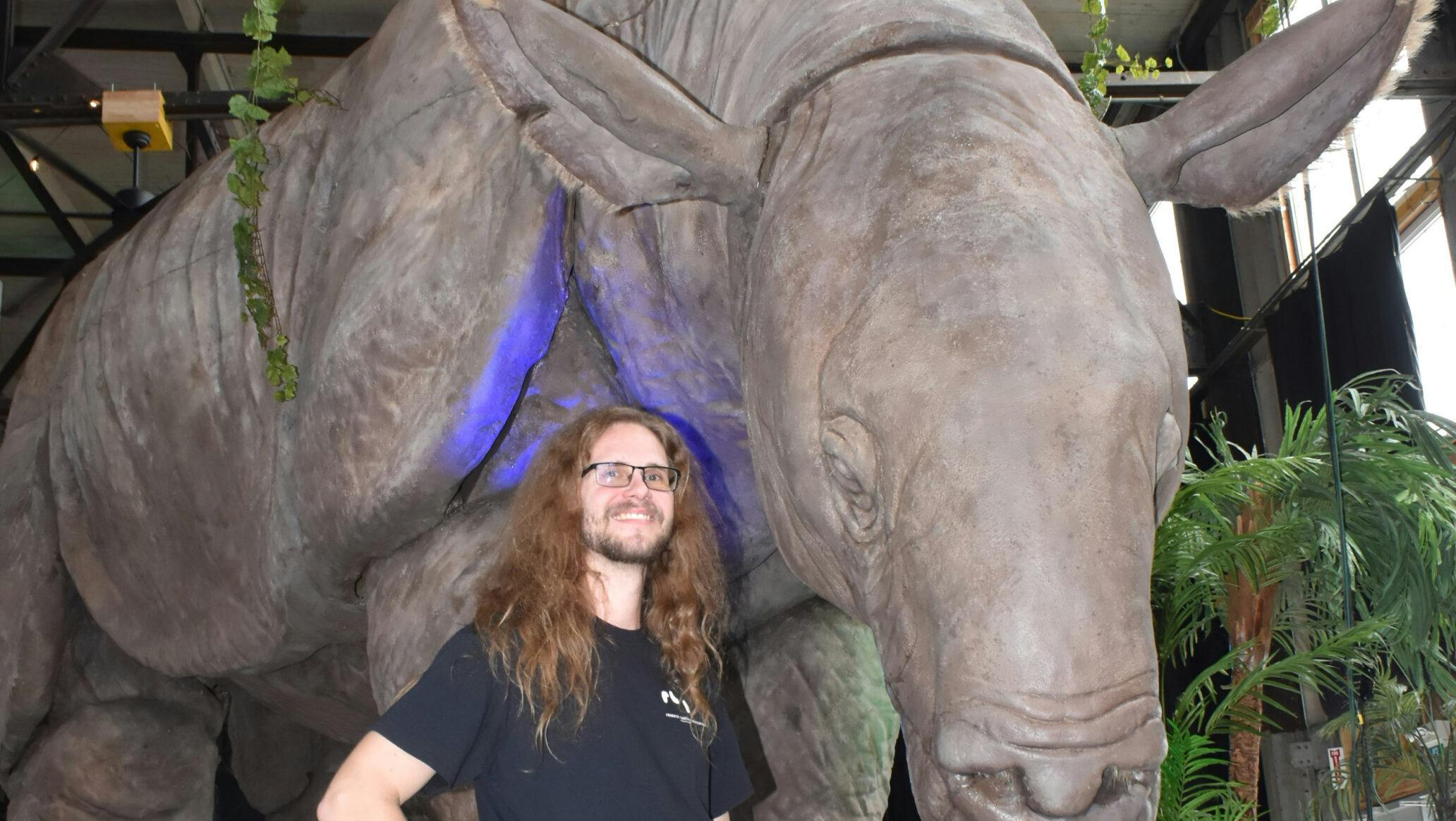 <p>FRIENDS IN HIGH PLACES- Research Casting International&#8217;s Ozz Macdonald with a life-sized example of an indricotherium, a hornless rhino that lived in what is now known as Pakistan during the Paleogene period. (Jason Parks/Gazette Staff) </p>
